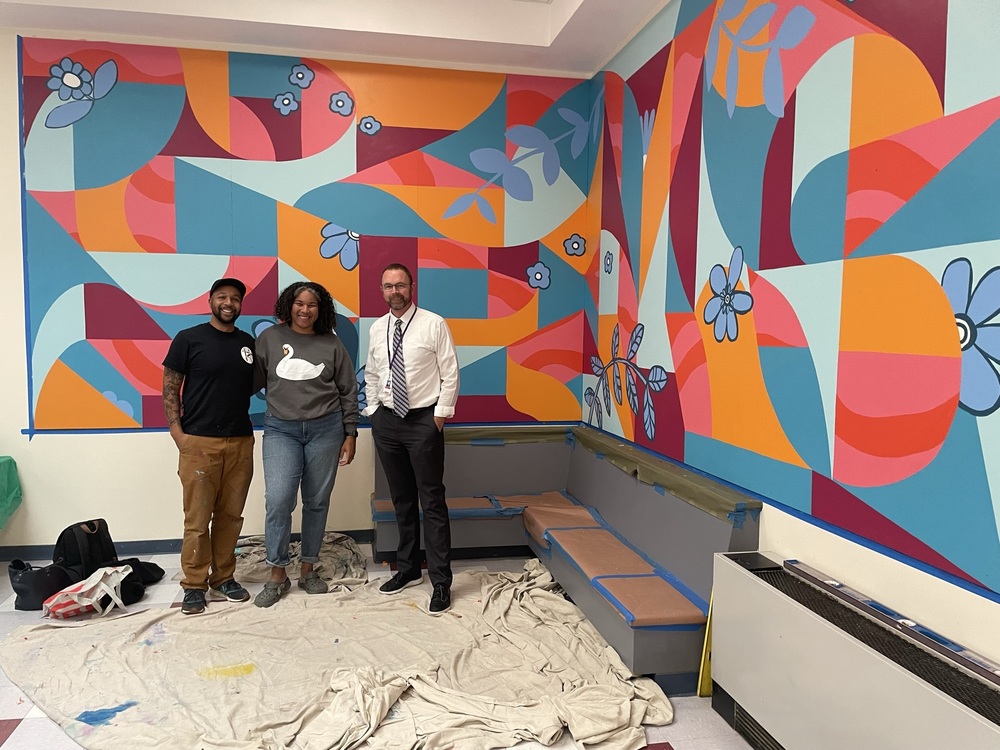 Dr. Record and visiting artists at CEMS stand in front of their mural