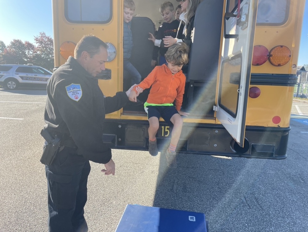 CE Officer helps student out of rear of school bus