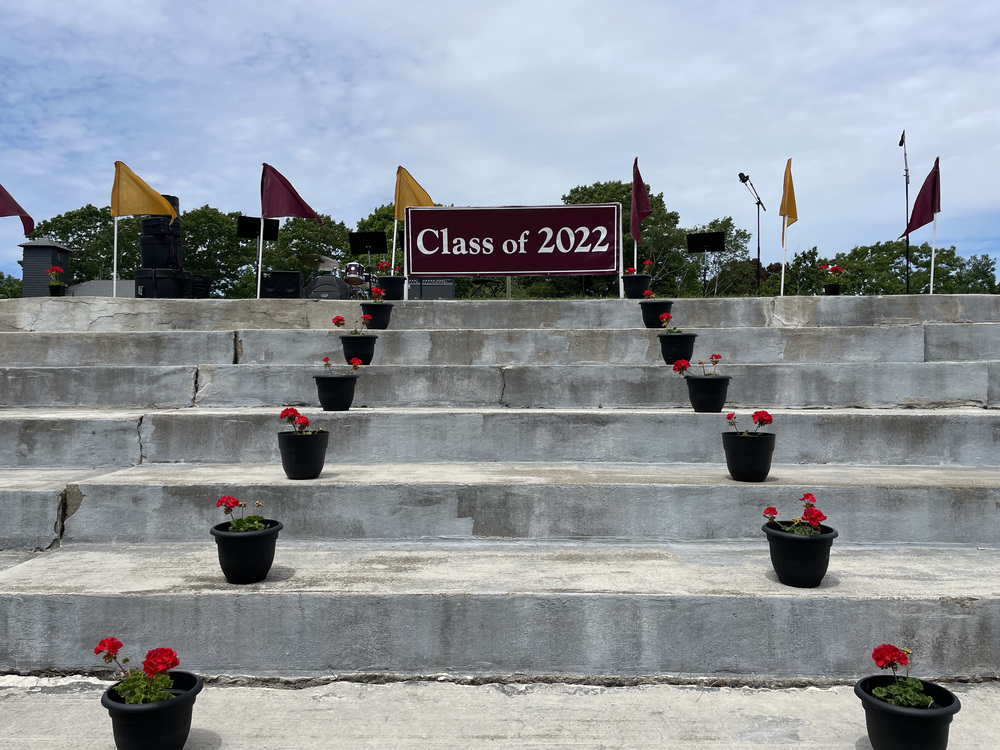 Class of 2022 sign at the top of stairs with flower pots on each stair.